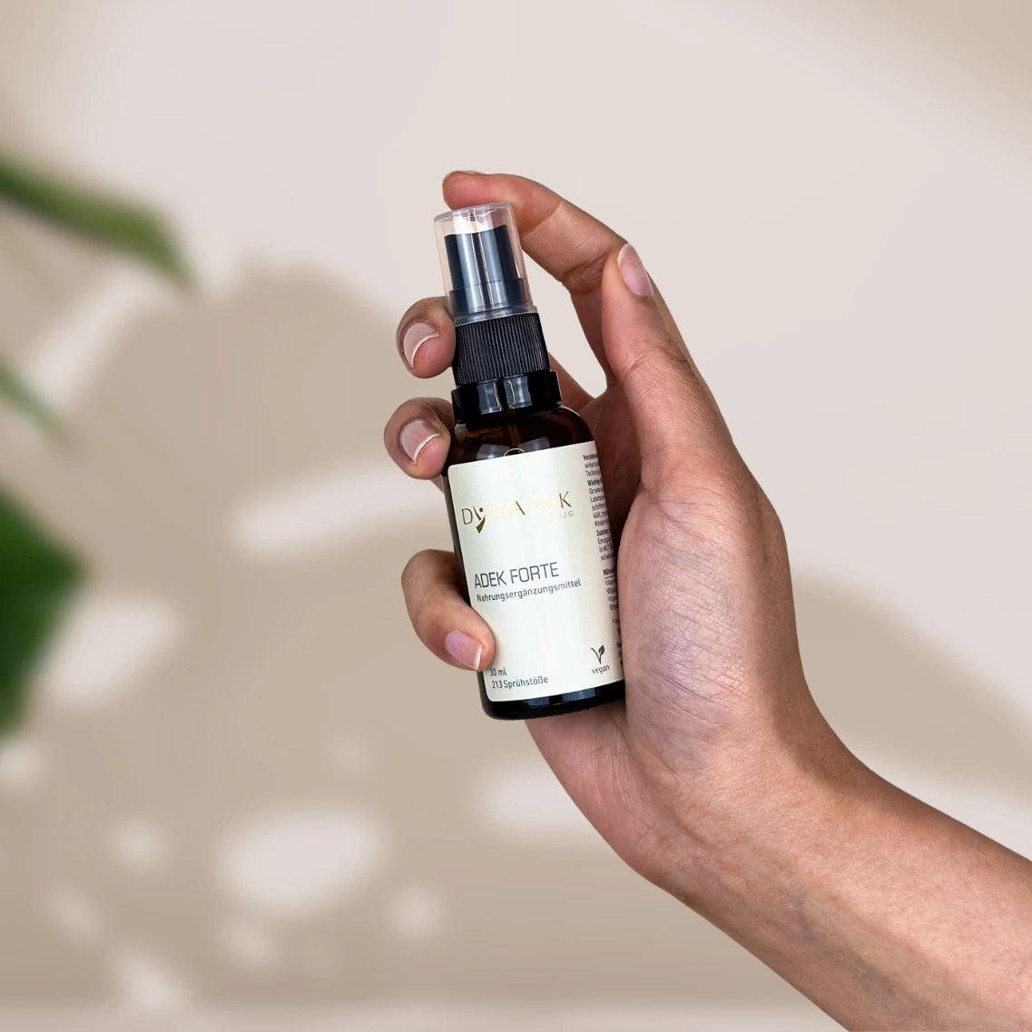 ADEK Forte Braunglas Sprühflasche in Hand Gebrauch Produktbild Spray Vitamine