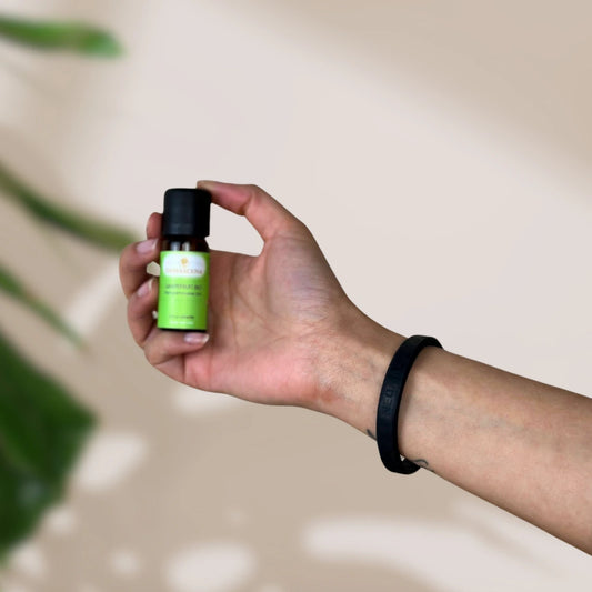 Kleines braunes Fläschchen mit grünem Aromaveda "Grapefruit Bio" Etikett in Hand gehalten
