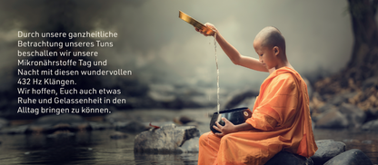 Junger Mönch mit Wasserschale mit der er einen schwarzen Topf befüllt sitzend an Teich
