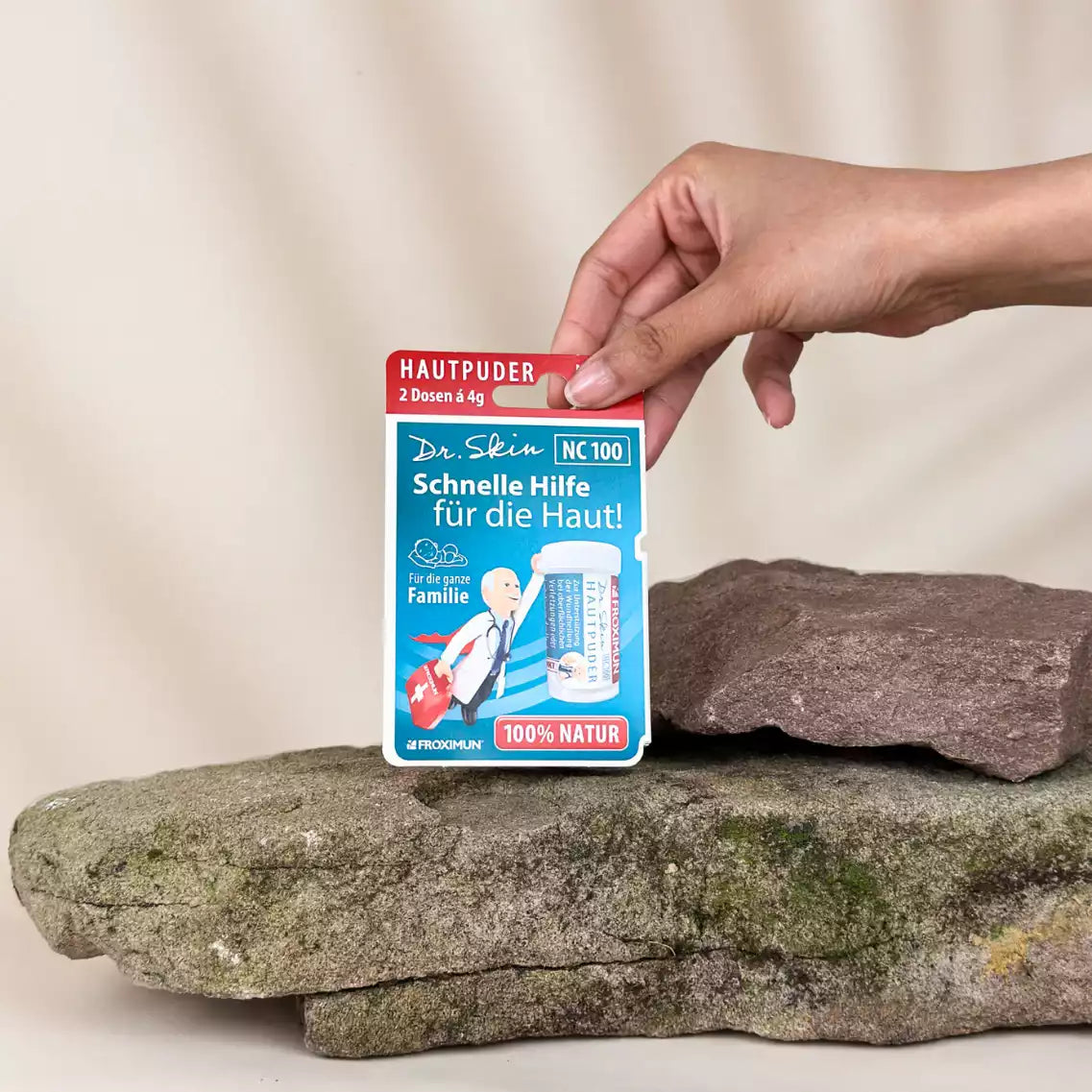 Blaue Verpackung mit "Dr. Skin Hautpuder" Druck und Arztabbildung