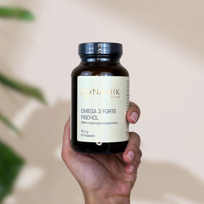 Brauner Glasbehälter mit DynamikPlus "Omega 3 Forte Fischöl" Etikett und schwarzem Drehverschluss von einer Hand gehalten