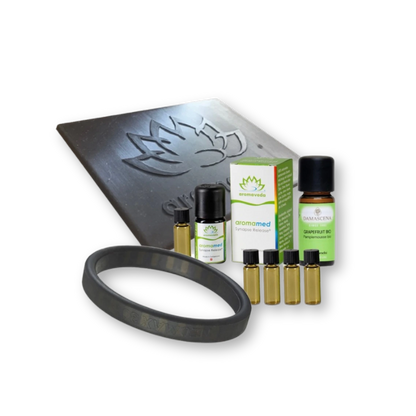 Rundum Wohlfühlpaket - aromaveda® Kollektion mit schwarzer Platte und Armband, kleines Fläschchen, größeres Fläschchen mit "Grapefruit Bio" Etikett und weiße Verpackung mit grünem aromaveda Druck