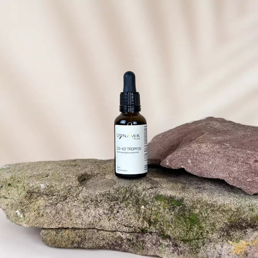 Braune Tröpfchenflasche mit DynamikPlus "Vitamin D3 + K2 Tropfen" Etikett auf der Flasche